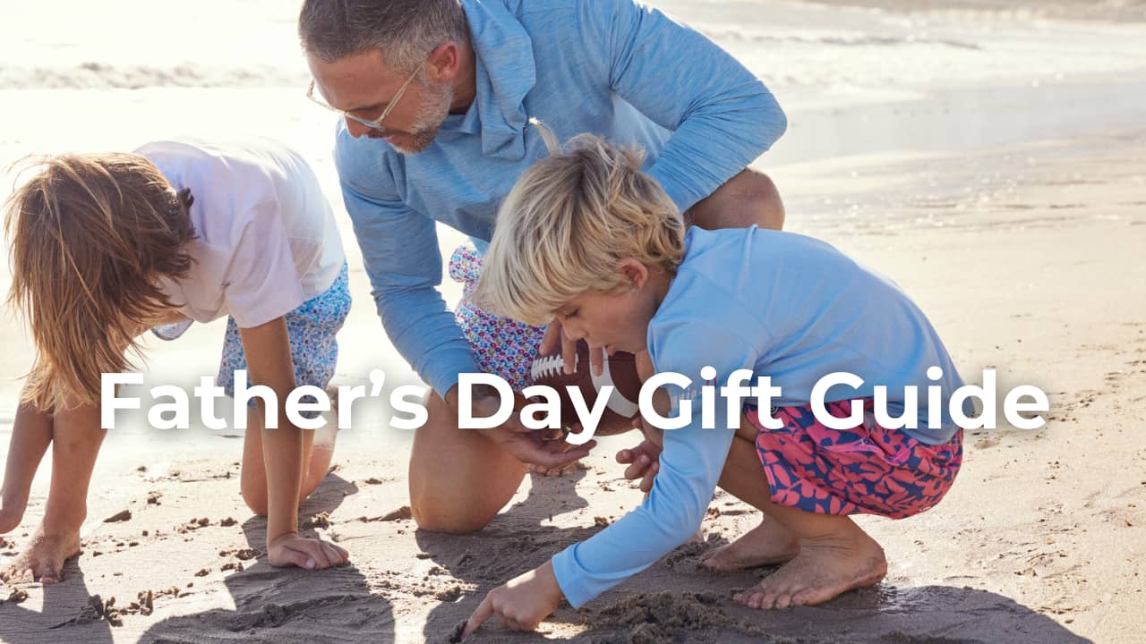 A father and two kids playing in the sand behind the text "Father's day gift guide"